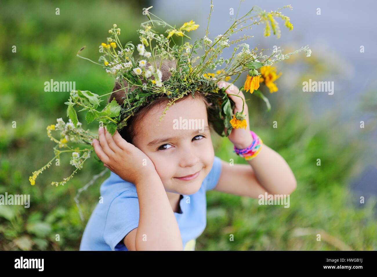 Babymädchen in einen Kranz von Wildblumen Stockfoto