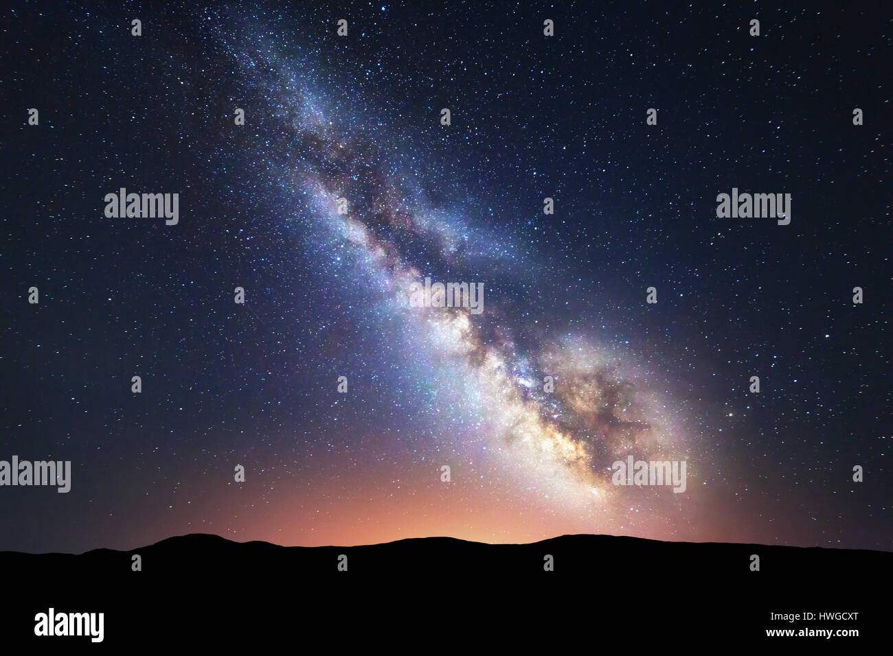 Milky Way. Fantastische Nachtlandschaft mit hellen Milchstraße Himmel voller Sterne, gelbe Stadt Lichter und Berge. Malerische Szenerie mit unserem Universum. S Stockfoto