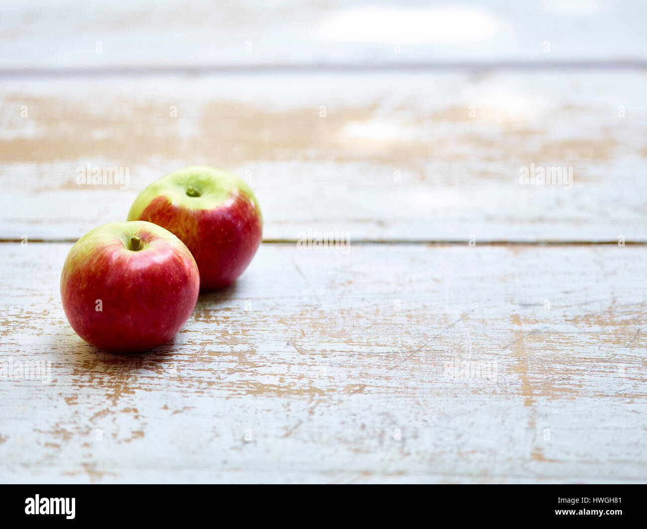 rote Äpfel auf weiß getünchten hölzernen Hintergrund Stockfoto