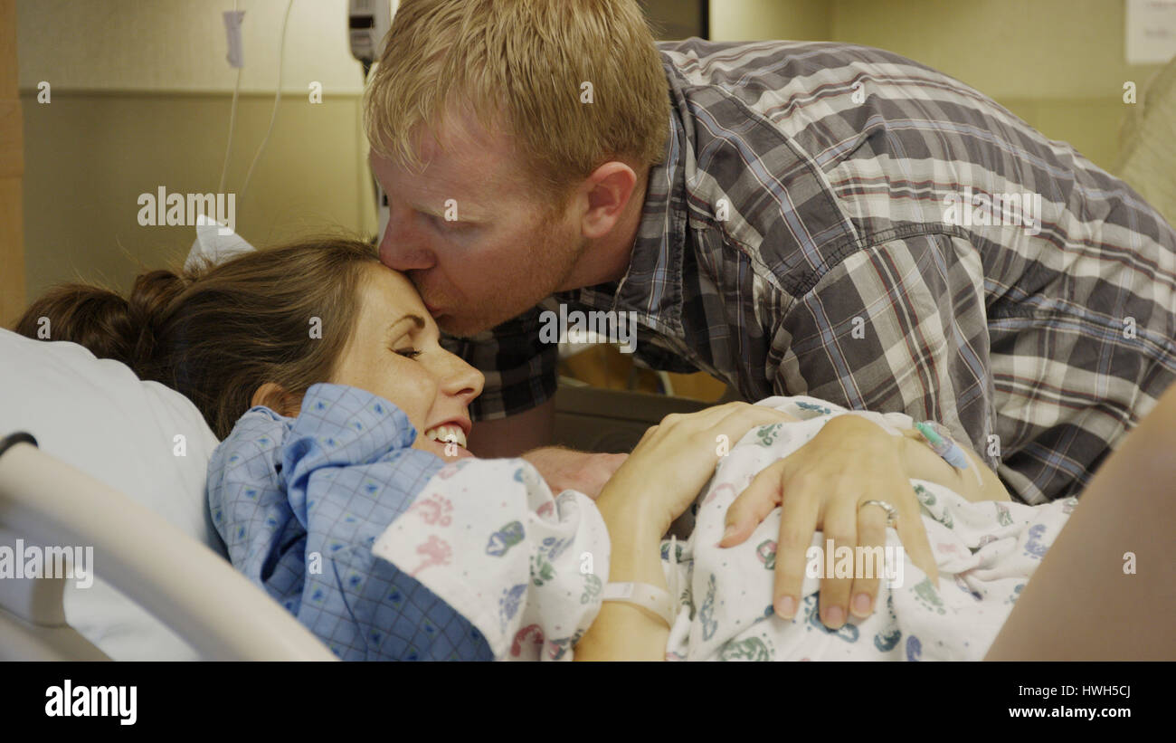Höhenplan der neuen Mutter und Vater bewundernden neugeborenes Baby im Krankenhaus Stockfoto