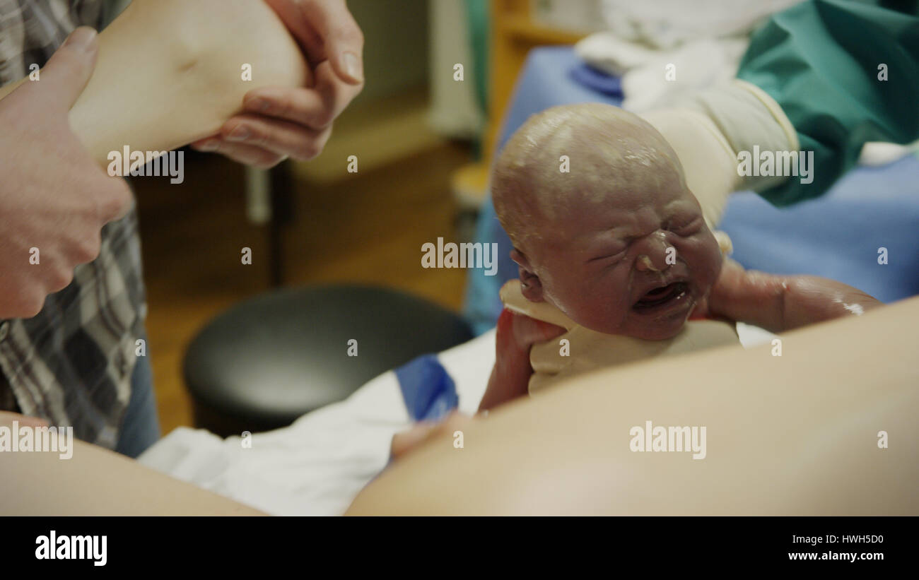 Selektiven Fokus Blick des Arztes helfen Mutter Geburt schreiendes neugeborenes Baby im Krankenhaus Stockfoto