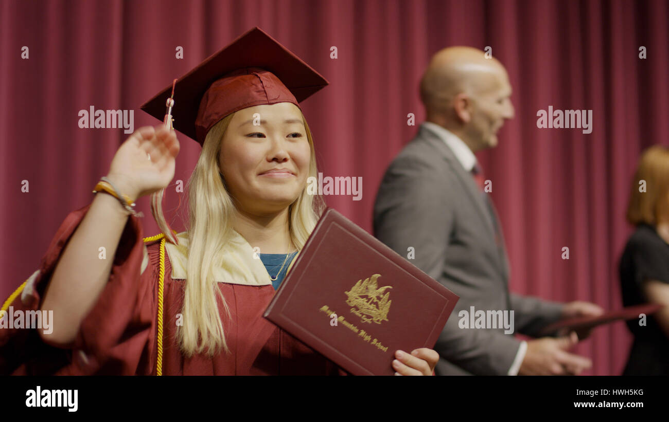 Verschwommene Sicht auf winken Student Diplom auf der Bühne während der Abschlussfeier zu halten Stockfoto