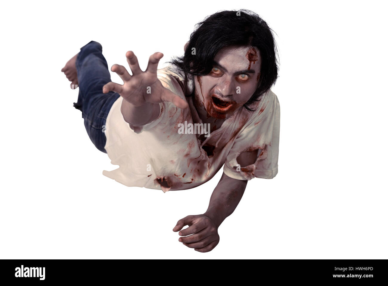Männlichen Zombie hocken auf dem Boden isoliert auf weißem Hintergrund Stockfoto