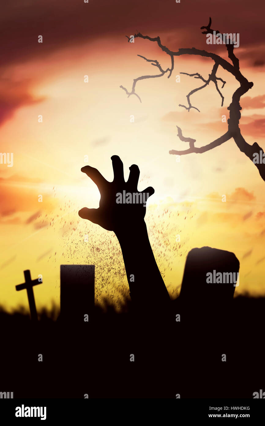 Silhouette Leiche Erziehung Hände von seinem Grab auf dem Friedhof bei Sonnenuntergang Stockfoto