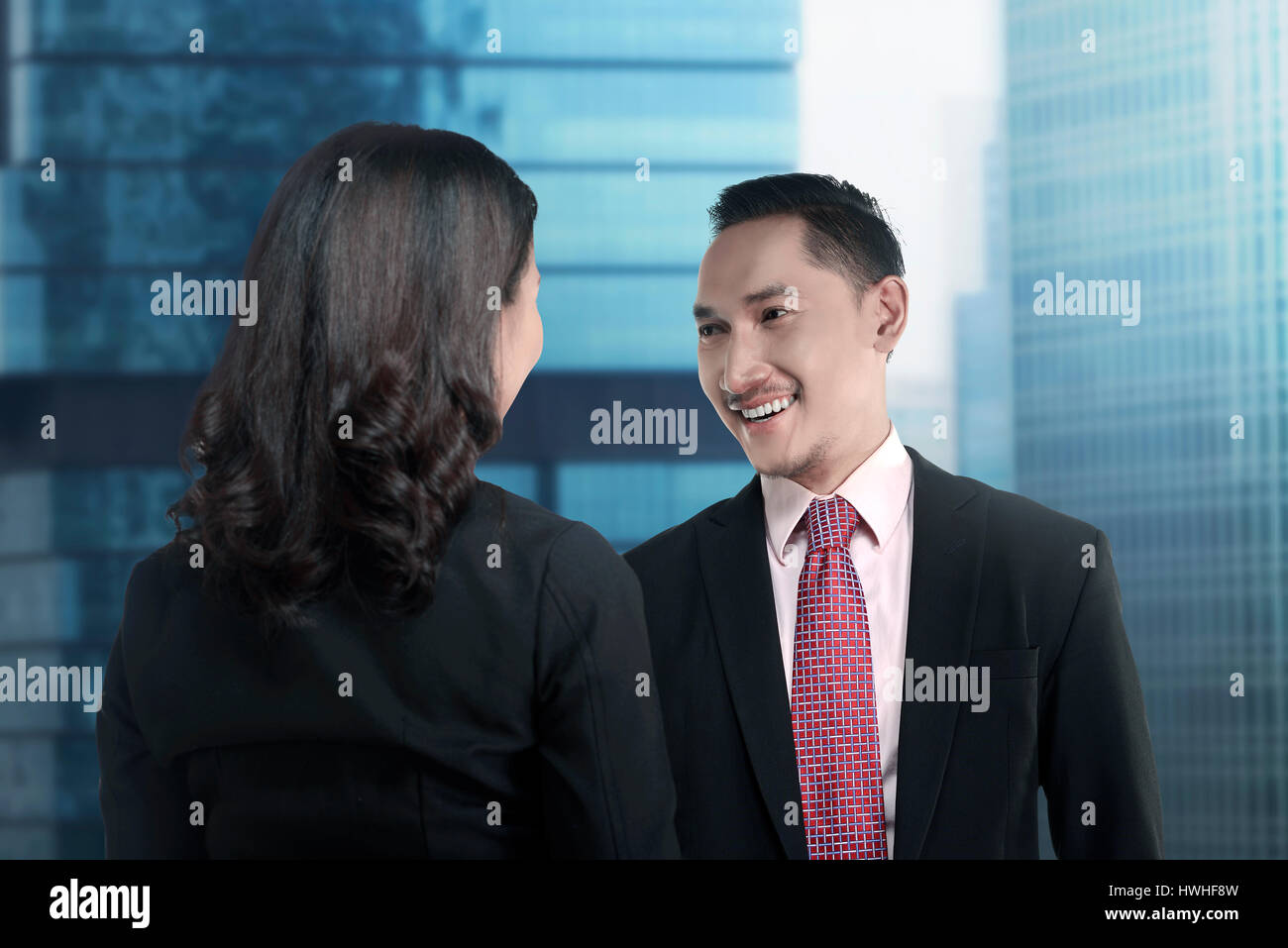 Casual Business-Meeting. Mann und Frau im Gespräch mit blauem Hintergrund Stockfoto