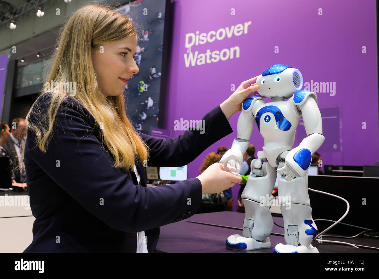 Hannover, Deutschland, 20. März 2017 - Messe CeBIT Digitaltechnik. Eine Gastgeberin Stand berührt einen humanoiden Roboter der NAO Watson auf dem IBM-stand Stockfoto