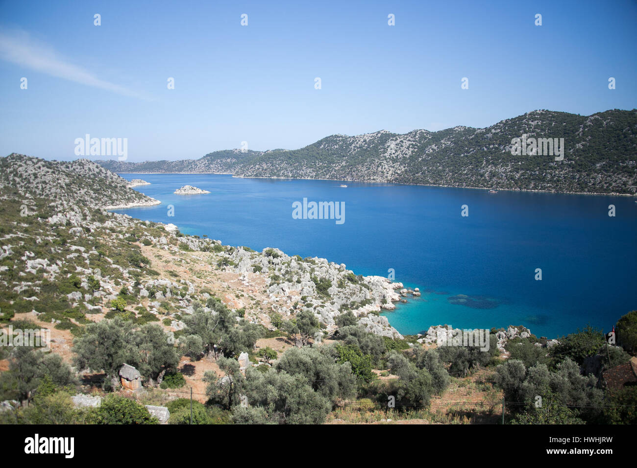 Blick auf Kalekoy Simena Bucht in Uchagiz Dorf von Antalya Provinz der Türkei mit lykischen Gräbern auf links und einige touristische Boote Stockfoto