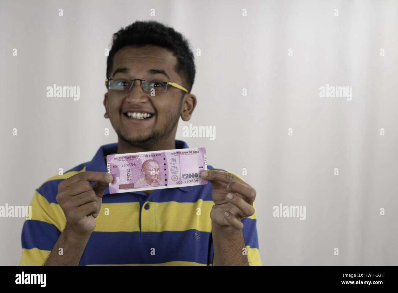Brillentragende glücklich zeigen zwei tausend Rupien Note, Post Geldentwertung in Indien Stockfoto
