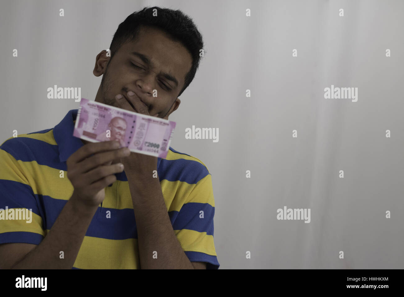 Mann, Beobachtung und denken über neu eingeführte zwei tausend Rupien Note, post Geldentwertung in Indien Stockfoto