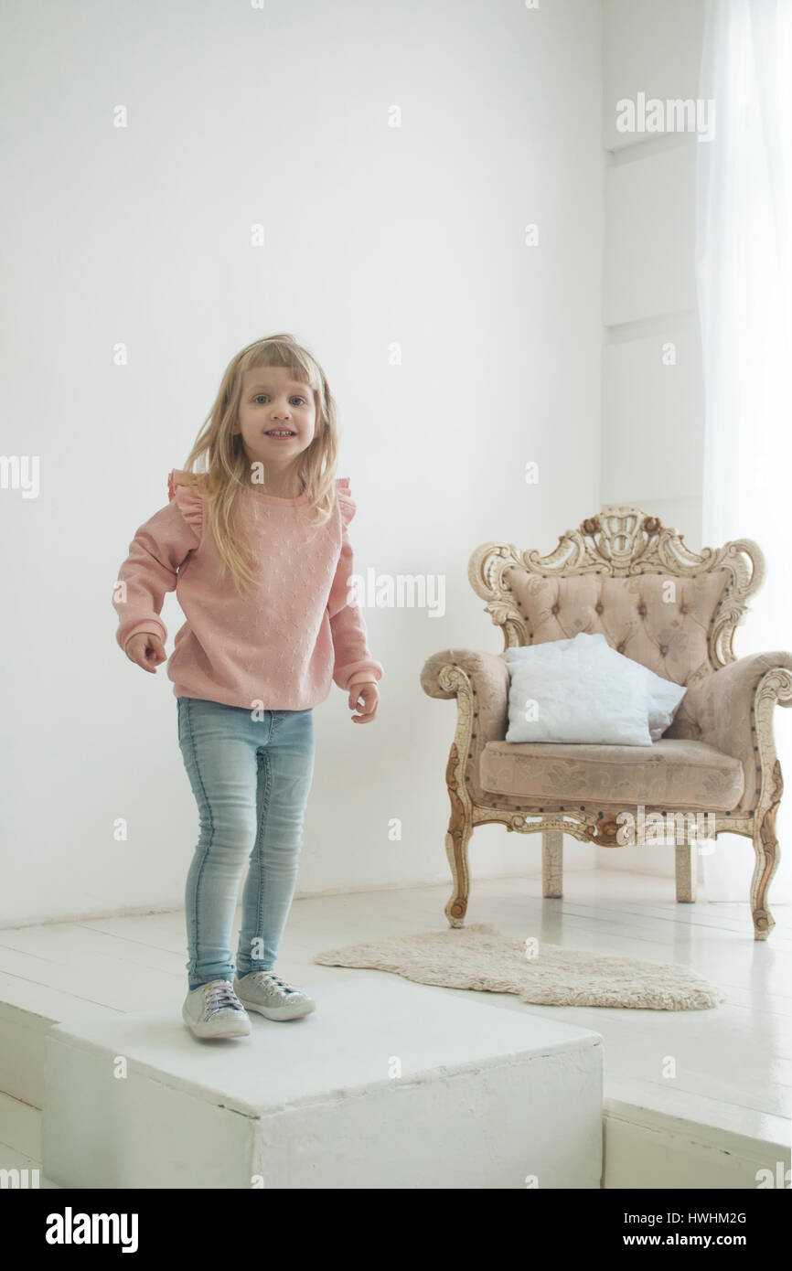 Wenig moderne Prinzessin in Jeans in der Nähe von ihrem Thron, weißer Hintergrund Stockfoto