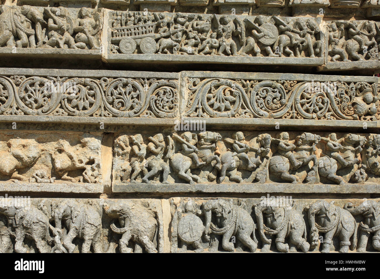 Detaillierte verzierten Stein schnitzen Darstellung Hindu-Mythologie, Laub, Reiter und Elefant Prozession auf Tafeln der Schrein Wand im Chennakesava Tempel Stockfoto