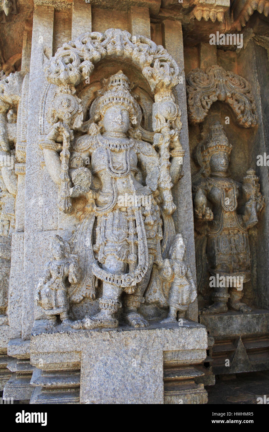 Nahaufnahme eines beschädigten Gottheit Skulptur unter Eves am Schrein Außenwand im Chennakesava Tempel, Hoysala Architektur an Somnathpur, Karnataka, Indien Stockfoto