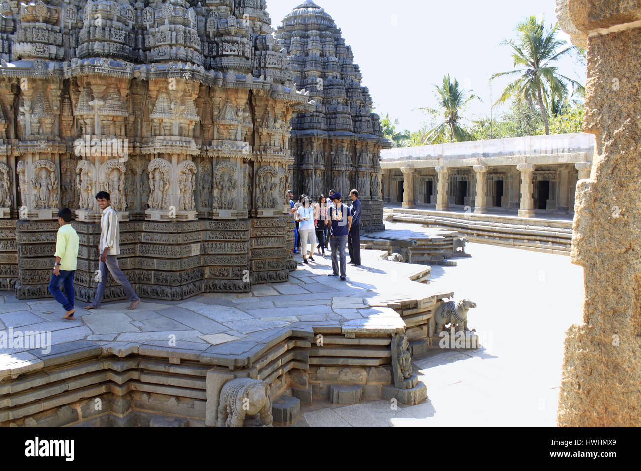 Touristen bewundern die Steinmetzarbeiten an den wichtigsten Schreinen im Chennakesava Bügel, Hoysala Architektur, Somnathpur, Karnataka, Indien Stockfoto