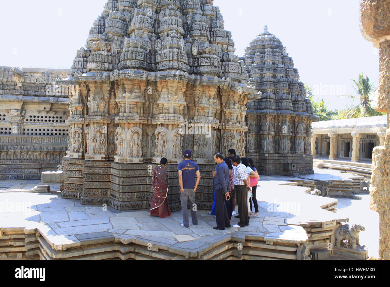 Touristen bewundern die Steinmetzarbeiten an den wichtigsten Schreinen im Chennakesava Bügel, Hoysala Architektur, Somnathpur, Karnataka, Indien Stockfoto