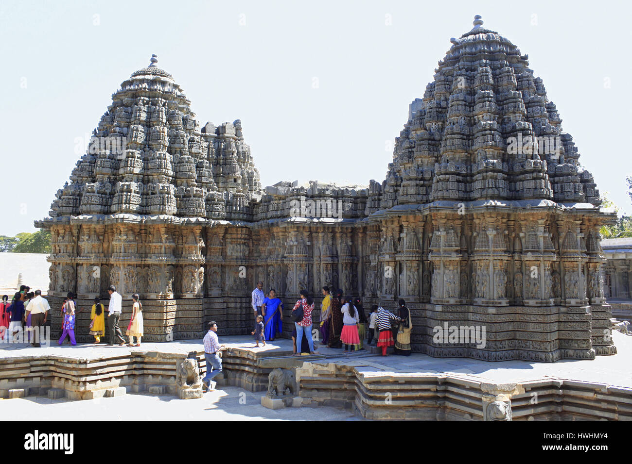 Rückansicht des Ganglion Schreine, Touristen bewundern die Steinmetzarbeiten am Chennakesava Tempel, Hoysala Architektur, Somnathpur, Karnataka, Indien Stockfoto