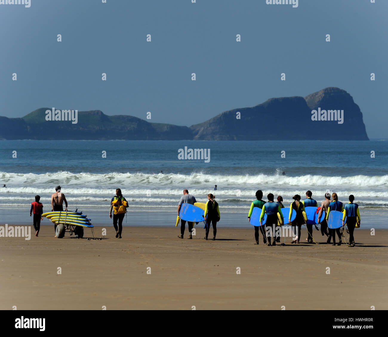 Surfschule auf einem flachen Sandstrand mit sanften Wellen und th kultigen Würmer Kopf Hintergrund Stockfoto
