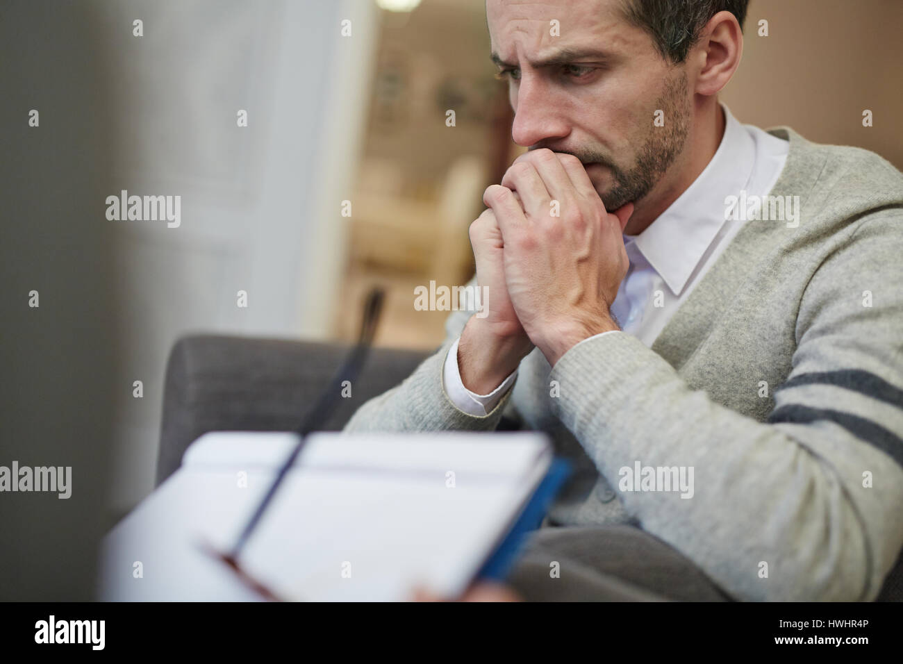 Taille-Up Portrait von enttäuscht bärtigen Patient versunken in Gedanken bei seinem Psychiater ärztlichen Fragebogen ausfüllen Stockfoto