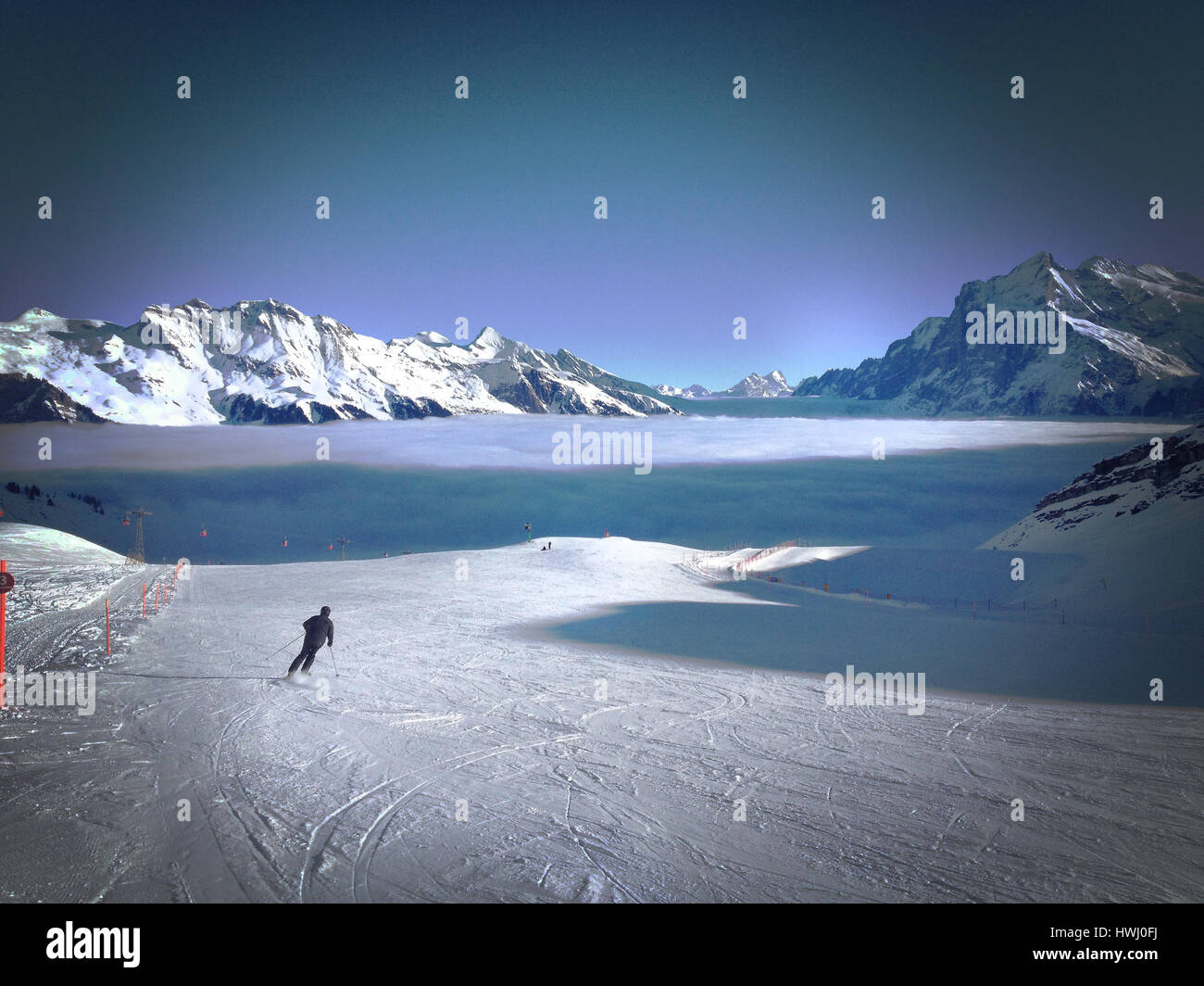 Einsamer Skifahrer über Wolken in der Schweiz Stockfoto