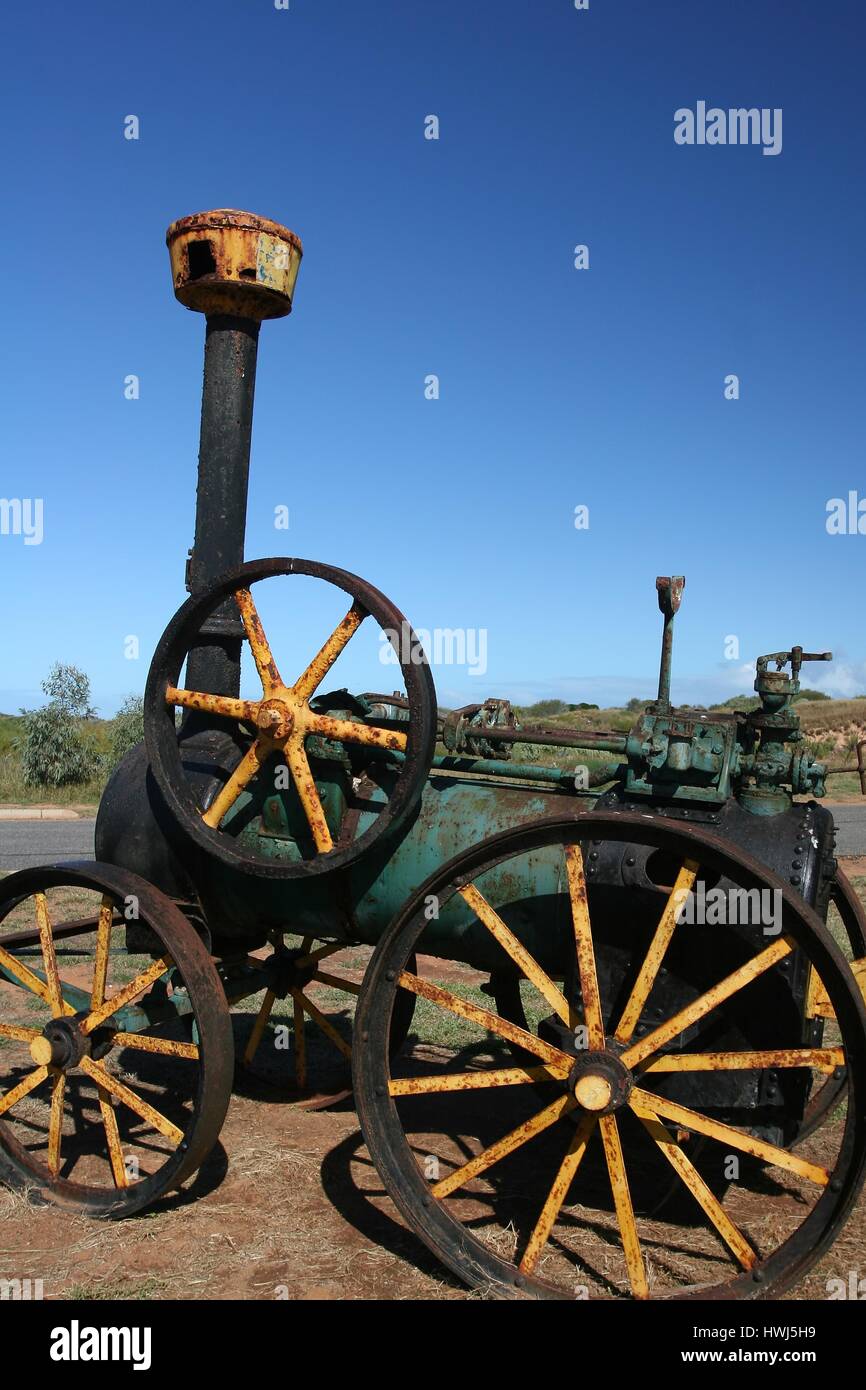 Carnarvon, Australien - 2008. Juni 28: Historischer schwarz-grün rostiger Dampflokomotiventraktor am Carnarvon Hafen und atemberaubender blauer Himmel. Stockfoto