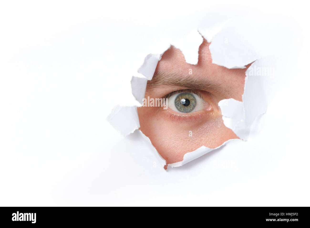 Auge, die durch ein Loch in einem Papier Stockfoto