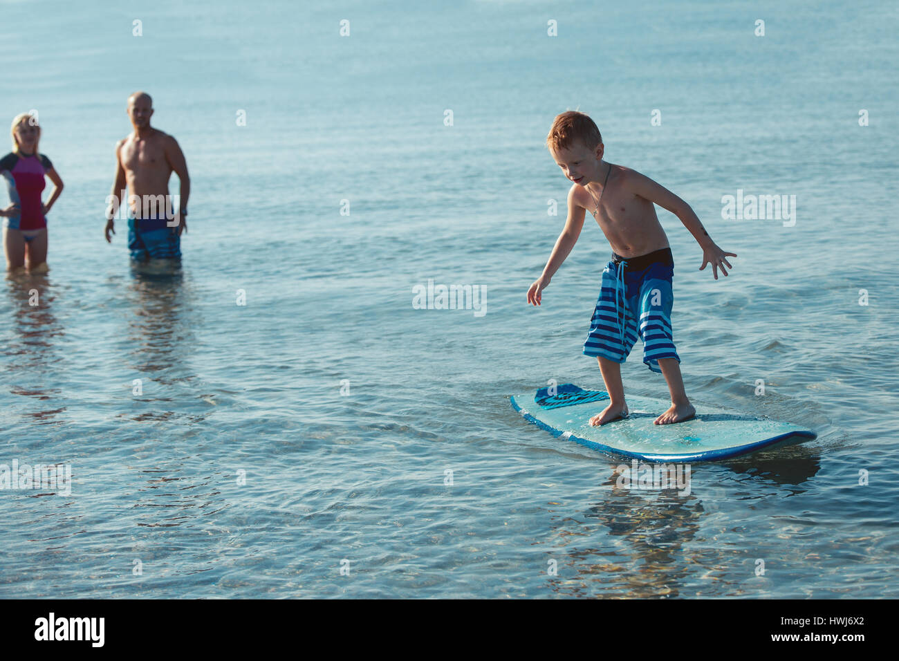 Sportliche Familie mit kleinen Jungen lehrte ihn Surfen Stockfoto