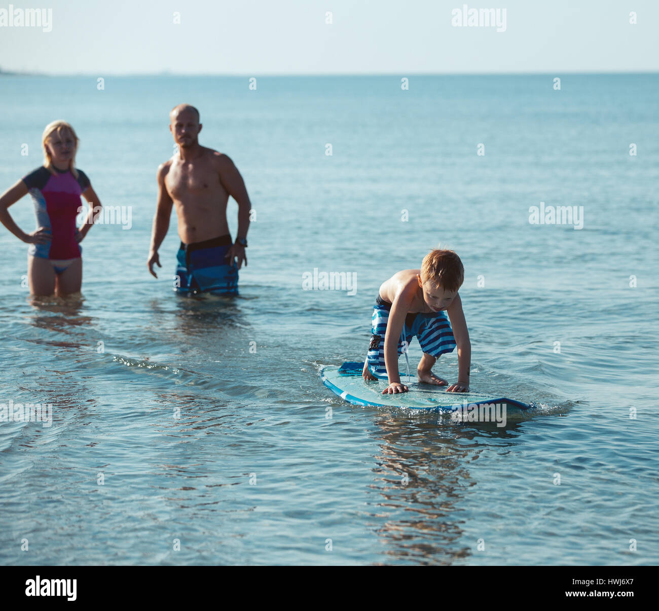 Sportliche Familie mit kleinen Jungen lehrte ihn Surfen Stockfoto