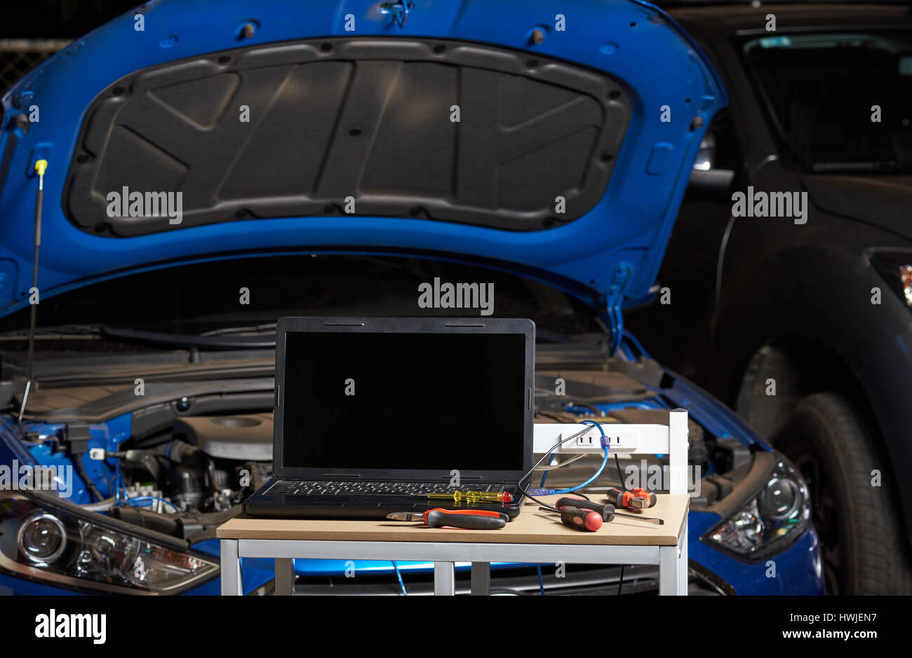 Moderne Werkzeuge für Auto Diagnose auf Weichzeichnen blaue Fahrzeug Hintergrund. Moderne Auto Reparatur Stockfoto