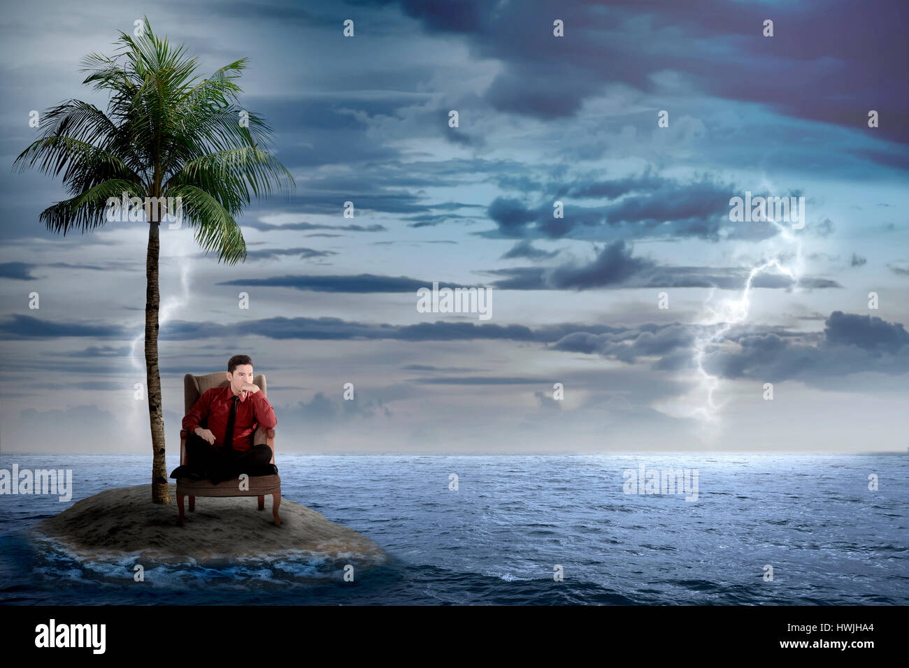 Asien-Geschäftsmann sitzen auf dem Stuhl, allein auf der kleinen Insel an etwas denken Stockfoto