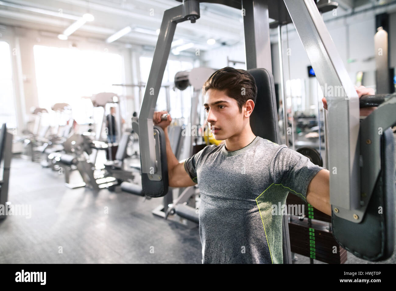 Junge spanische Fitness Mann im Fitness-Studio arbeitet über Schmetterling Fitnessgerät mit Gewichten, Muskeln Stockfoto