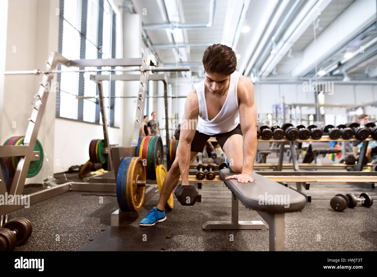 Junge spanische Fitness Mann im Fitnessstudio auf Bank, trainieren mit Gewichten Stockfoto