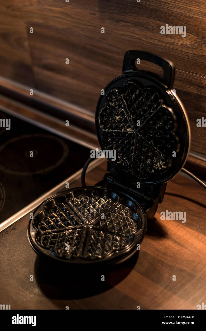 Hausgemachte Waffeln werden in einem Waffeleisen zubereitet. Stockfoto