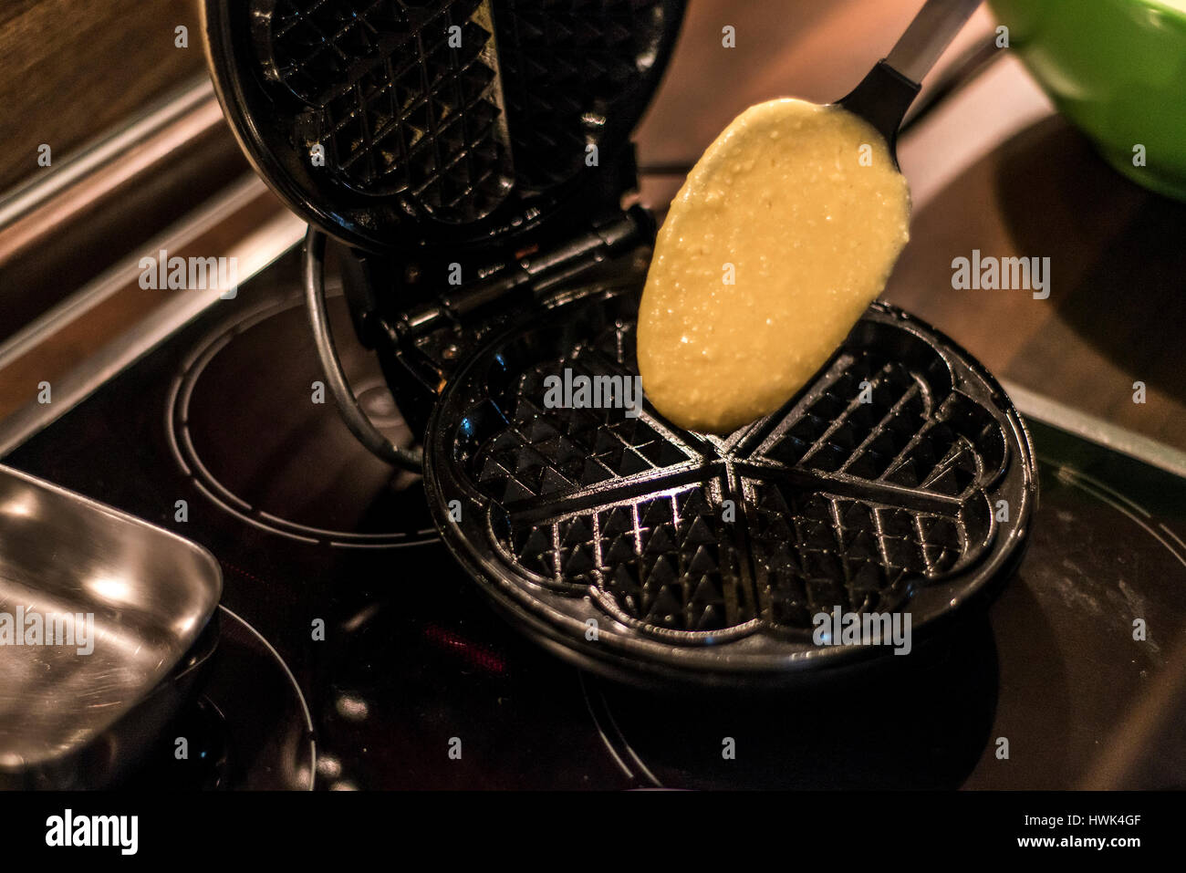 Hausgemachte Waffeln werden in einem Waffeleisen zubereitet. Stockfoto