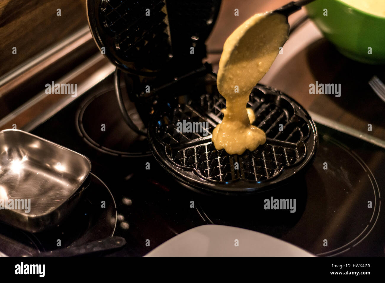 Hausgemachte Waffeln werden in einem Waffeleisen zubereitet. Stockfoto