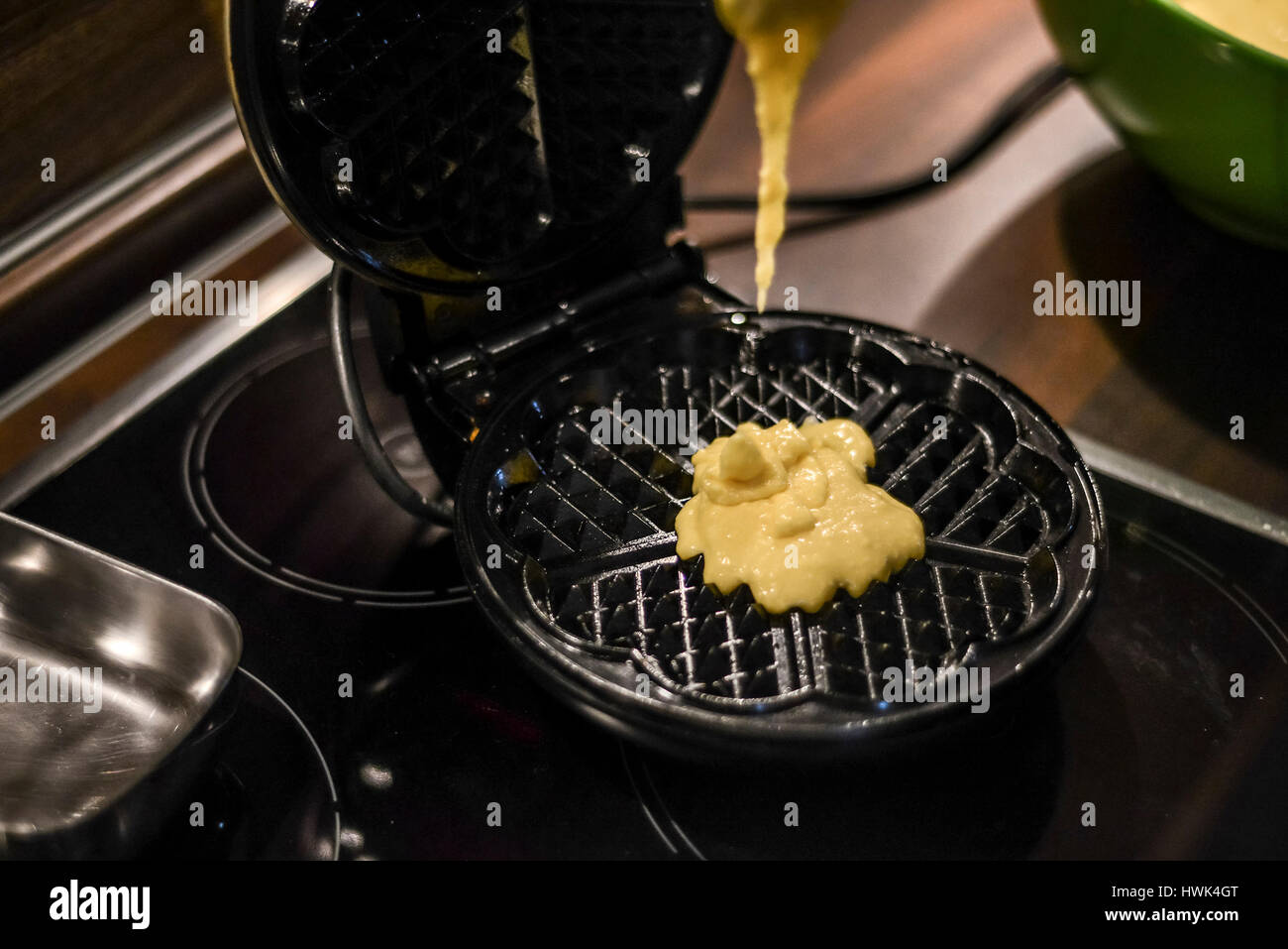 Hausgemachte Waffeln werden in einem Waffeleisen zubereitet. Stockfoto