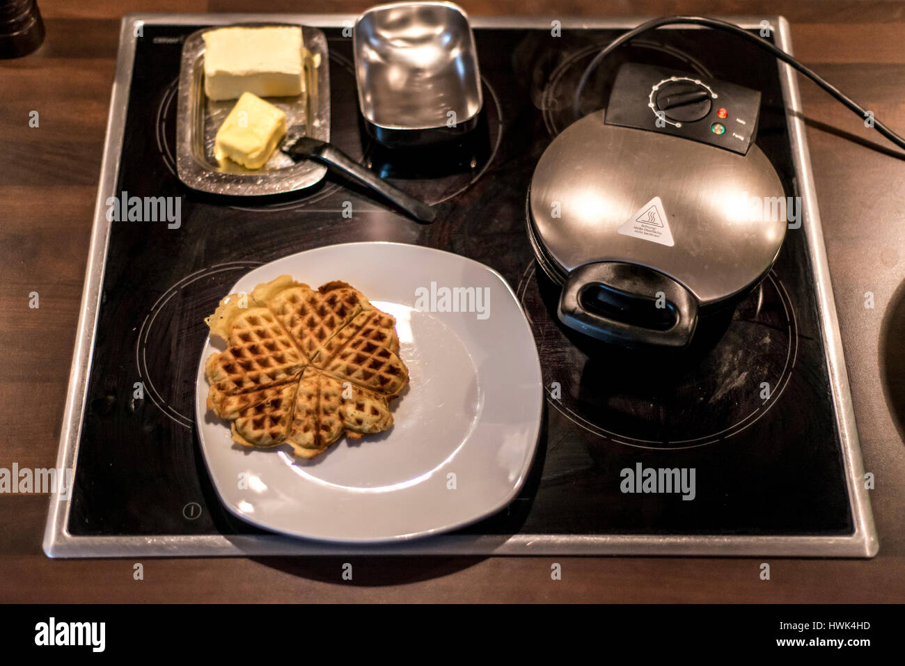 Hausgemachte Waffeln werden in einem Waffeleisen zubereitet. Stockfoto