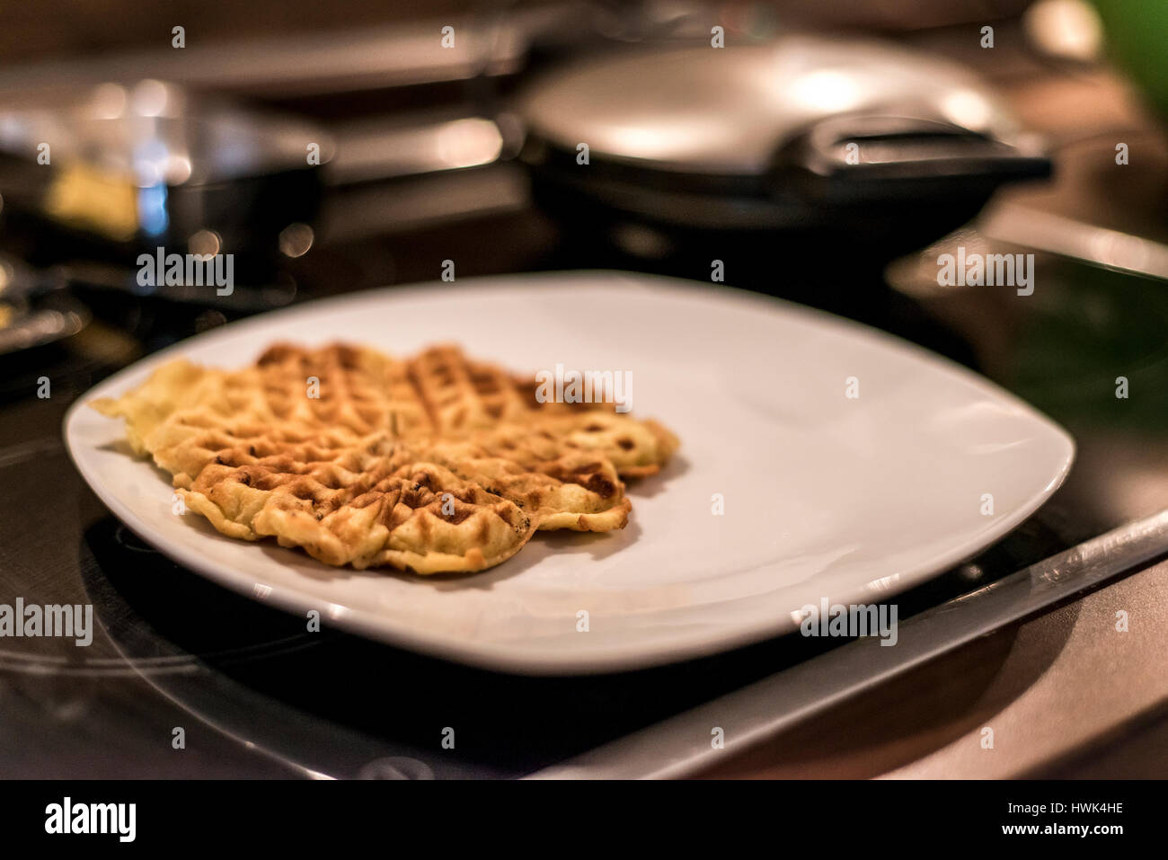 Hausgemachte Waffeln werden in einem Waffeleisen zubereitet. Stockfoto