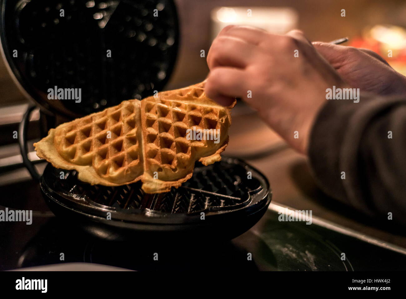 Hausgemachte Waffeln werden in einem Waffeleisen zubereitet. Stockfoto