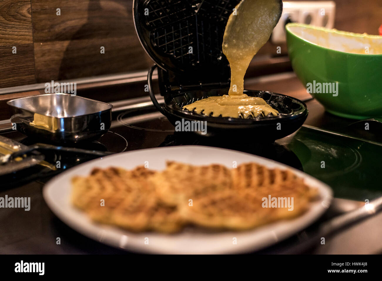 Hausgemachte Waffeln werden in einem Waffeleisen zubereitet. Stockfoto