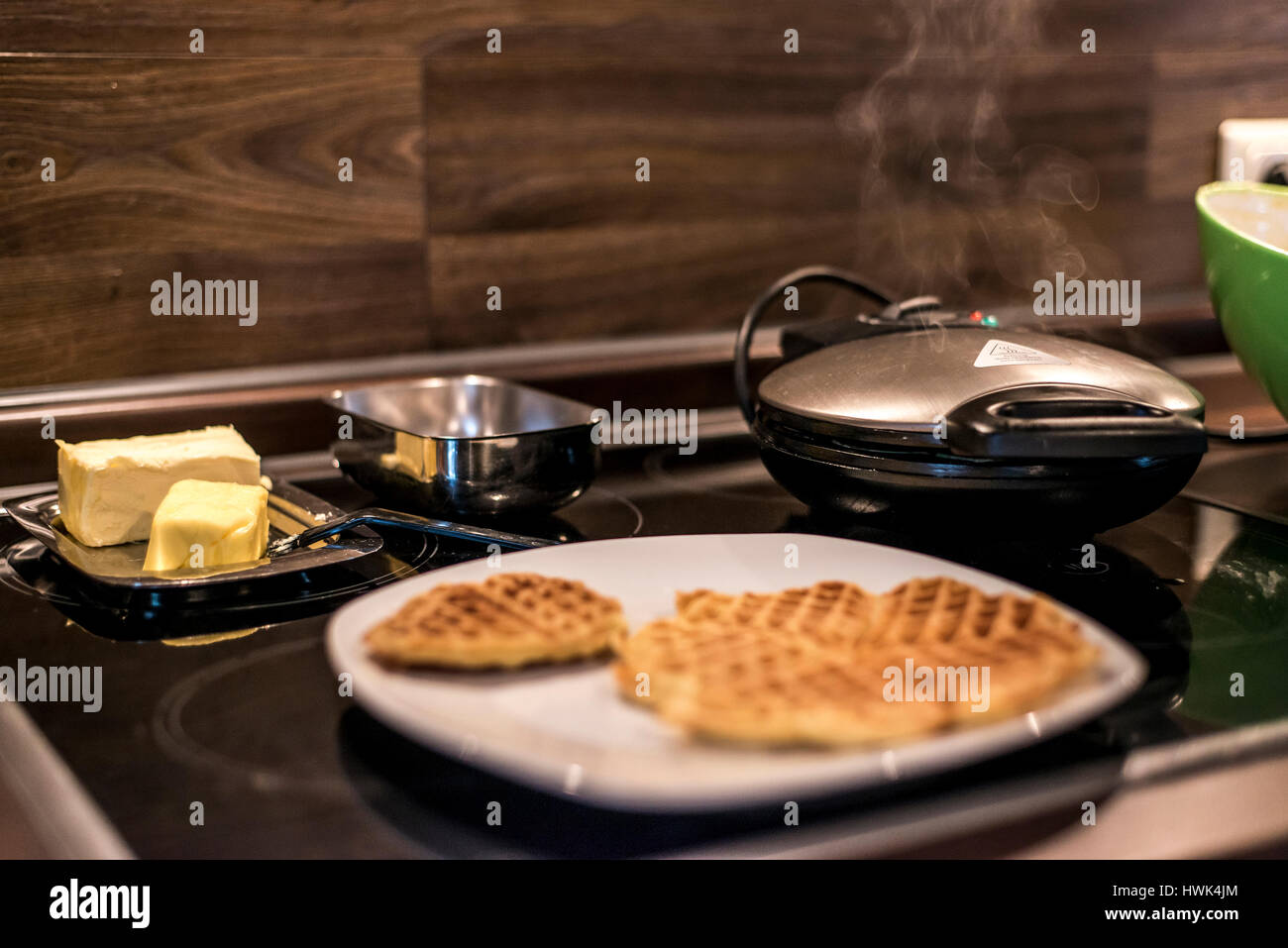 Hausgemachte Waffeln werden in einem Waffeleisen zubereitet. Stockfoto