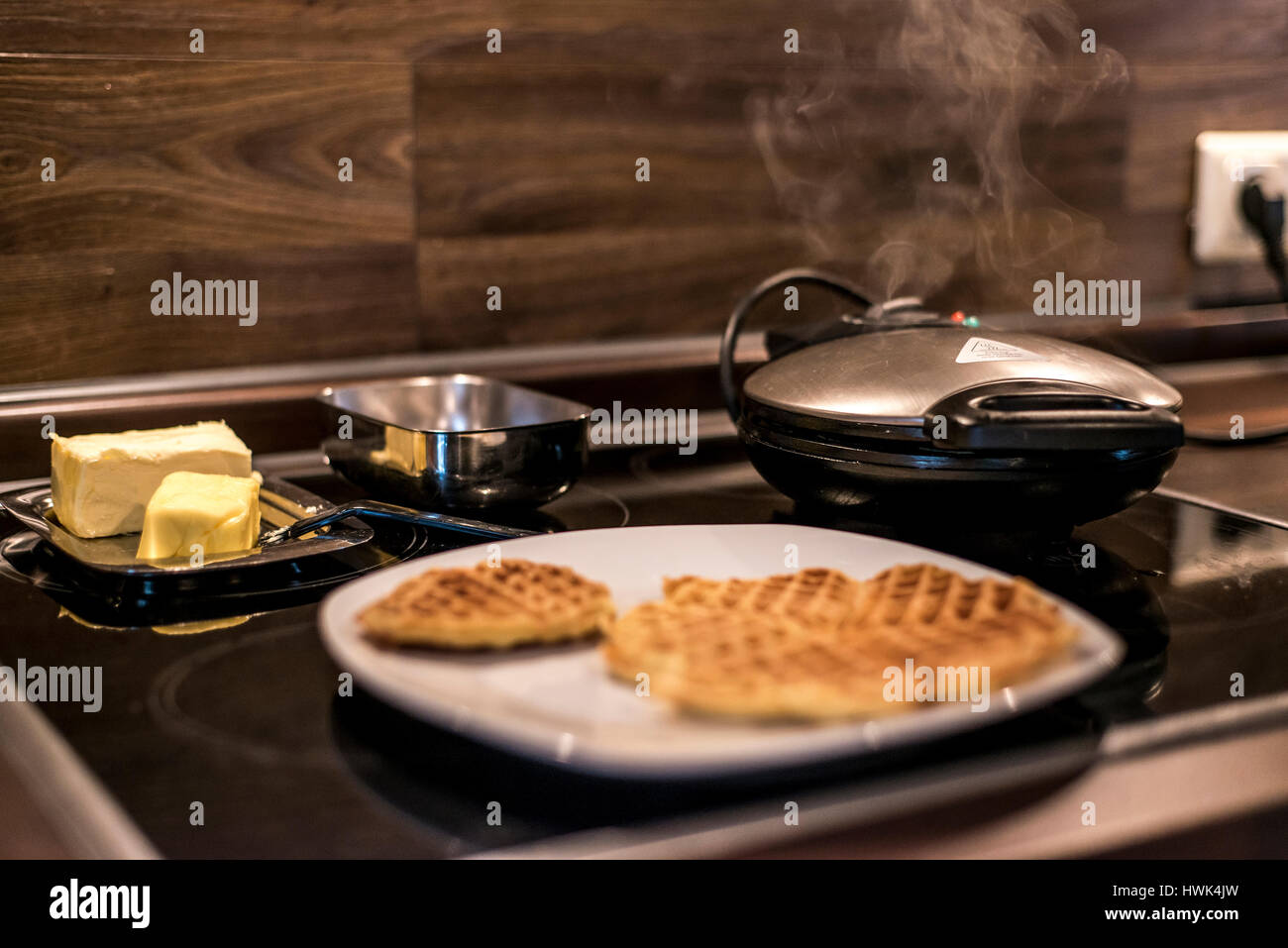Hausgemachte Waffeln werden in einem Waffeleisen zubereitet. Stockfoto