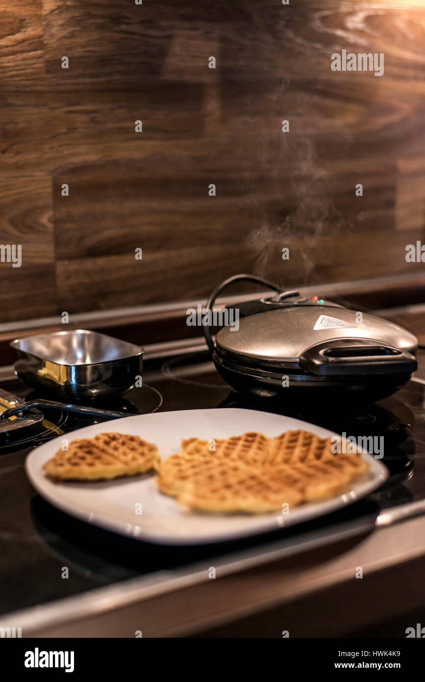 Hausgemachte Waffeln werden in einem Waffeleisen zubereitet. Stockfoto