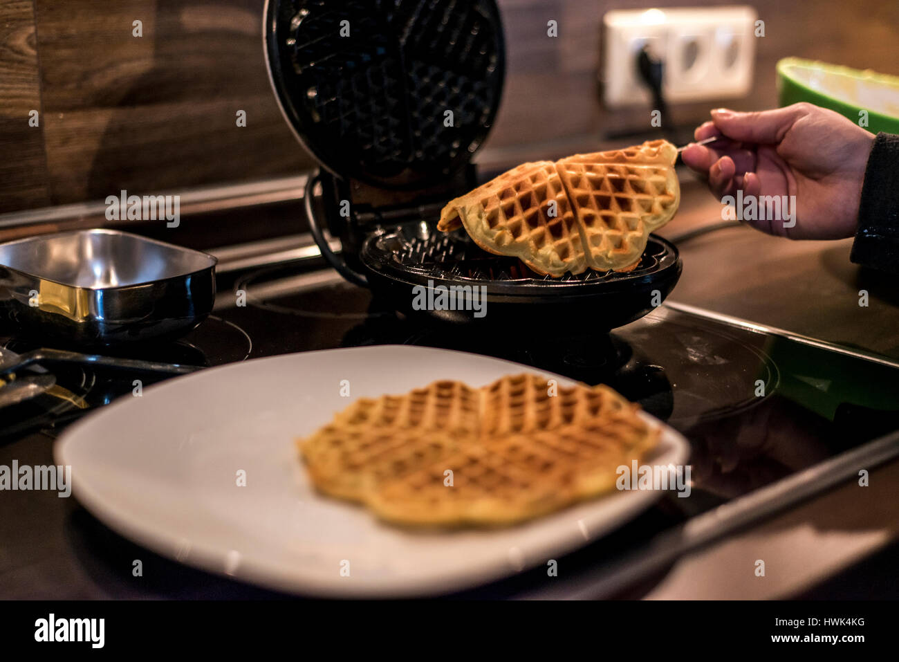 Hausgemachte Waffeln werden in einem Waffeleisen zubereitet. Stockfoto