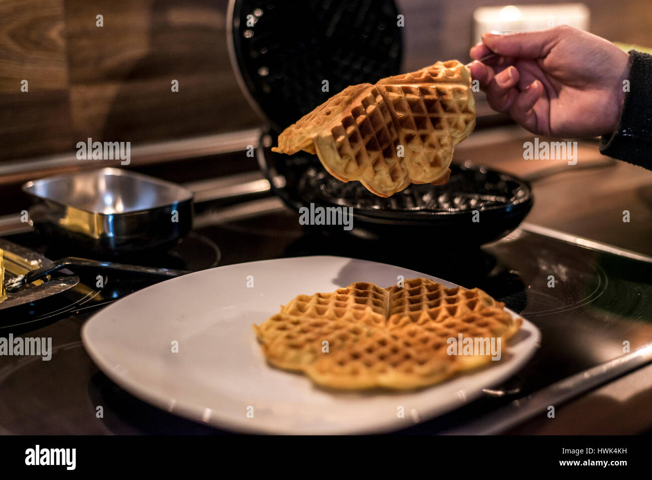 Hausgemachte Waffeln werden in einem Waffeleisen zubereitet. Stockfoto