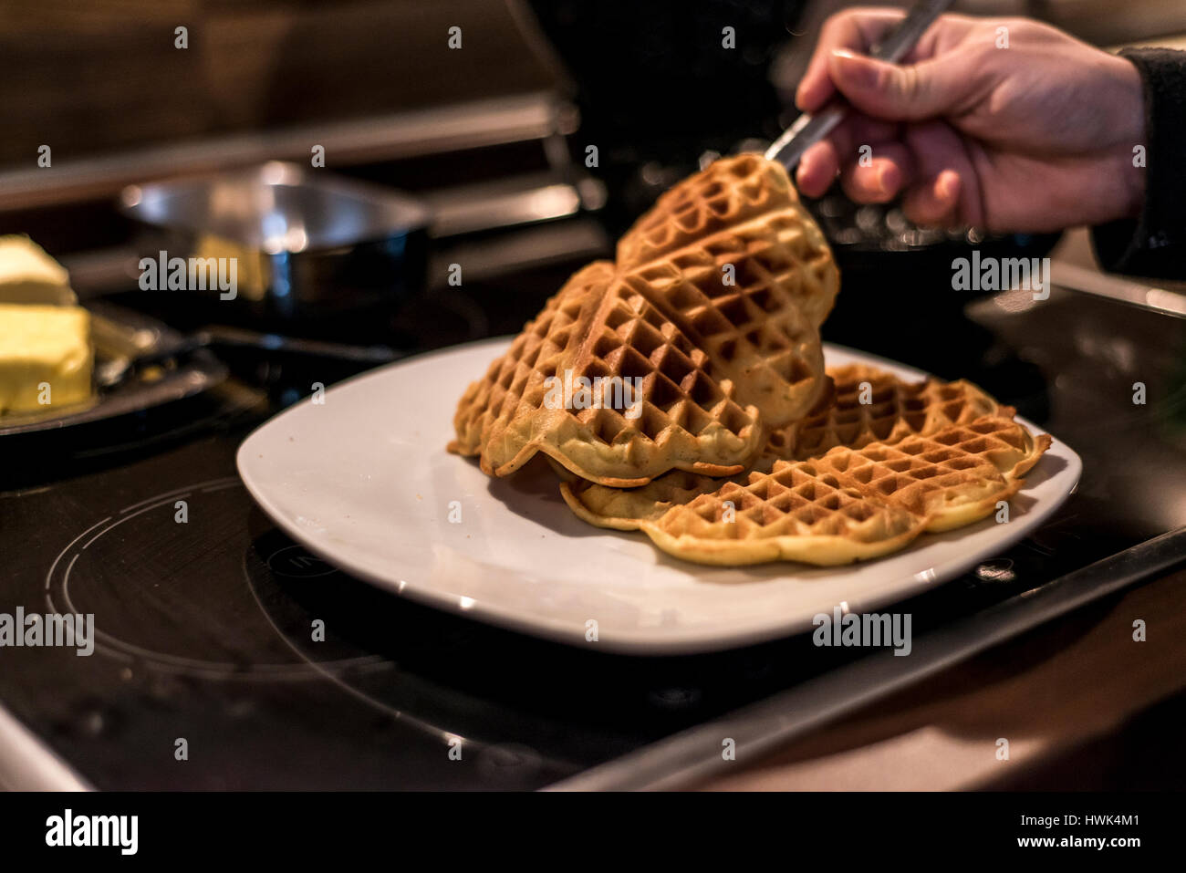 Hausgemachte Waffeln werden in einem Waffeleisen zubereitet. Stockfoto