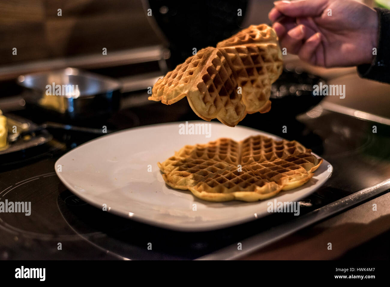 Hausgemachte Waffeln werden in einem Waffeleisen zubereitet. Stockfoto