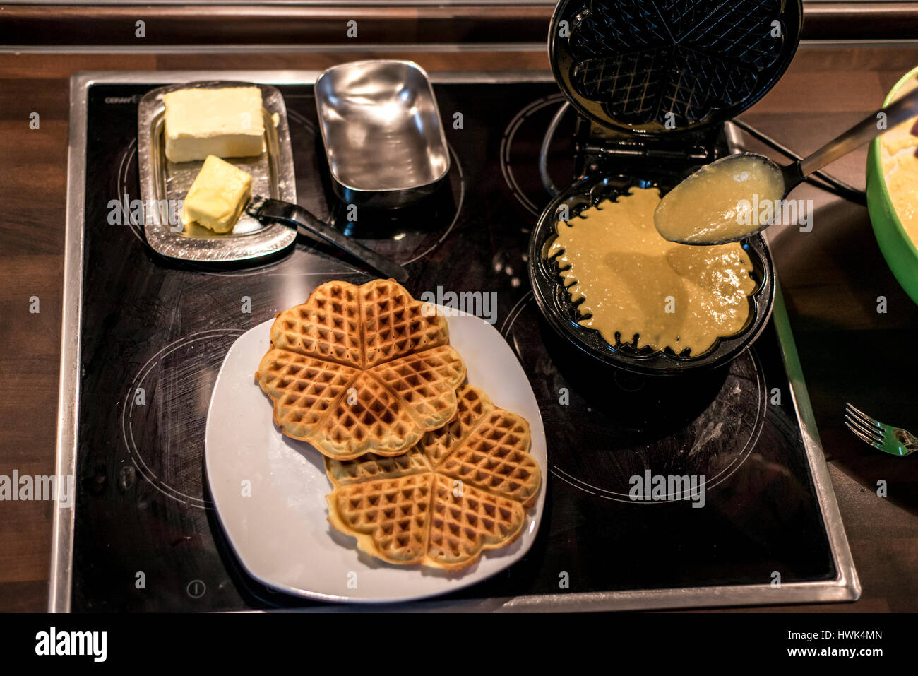 Hausgemachte Waffeln werden in einem Waffeleisen zubereitet. Stockfoto