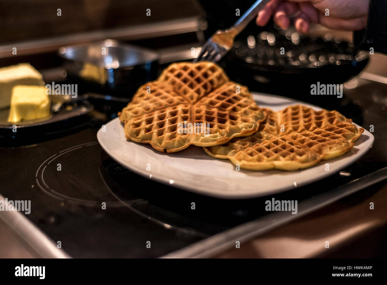 Hausgemachte Waffeln werden in einem Waffeleisen zubereitet. Stockfoto