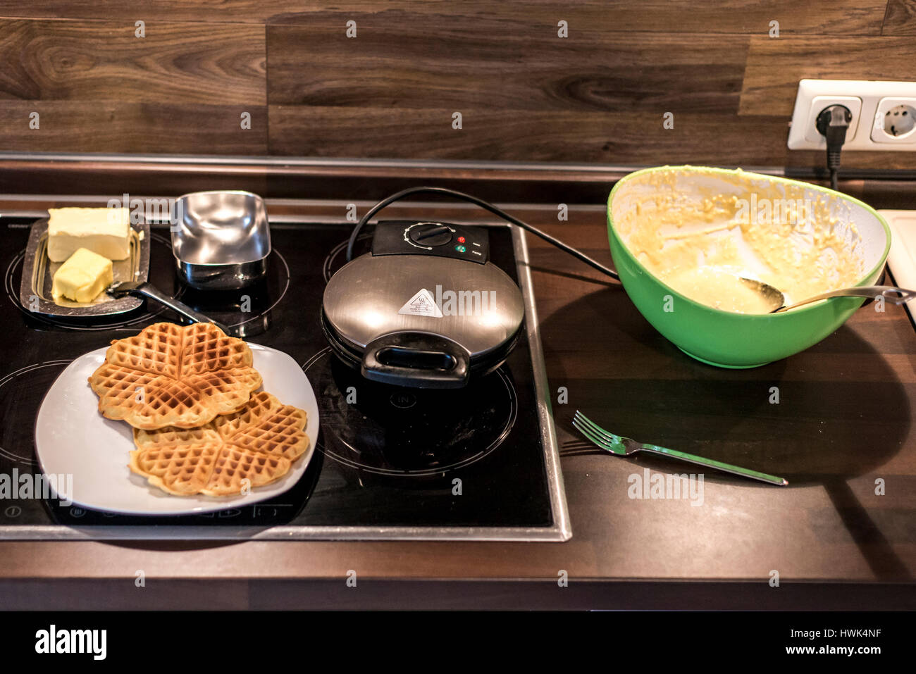Hausgemachte Waffeln werden in einem Waffeleisen zubereitet. Stockfoto
