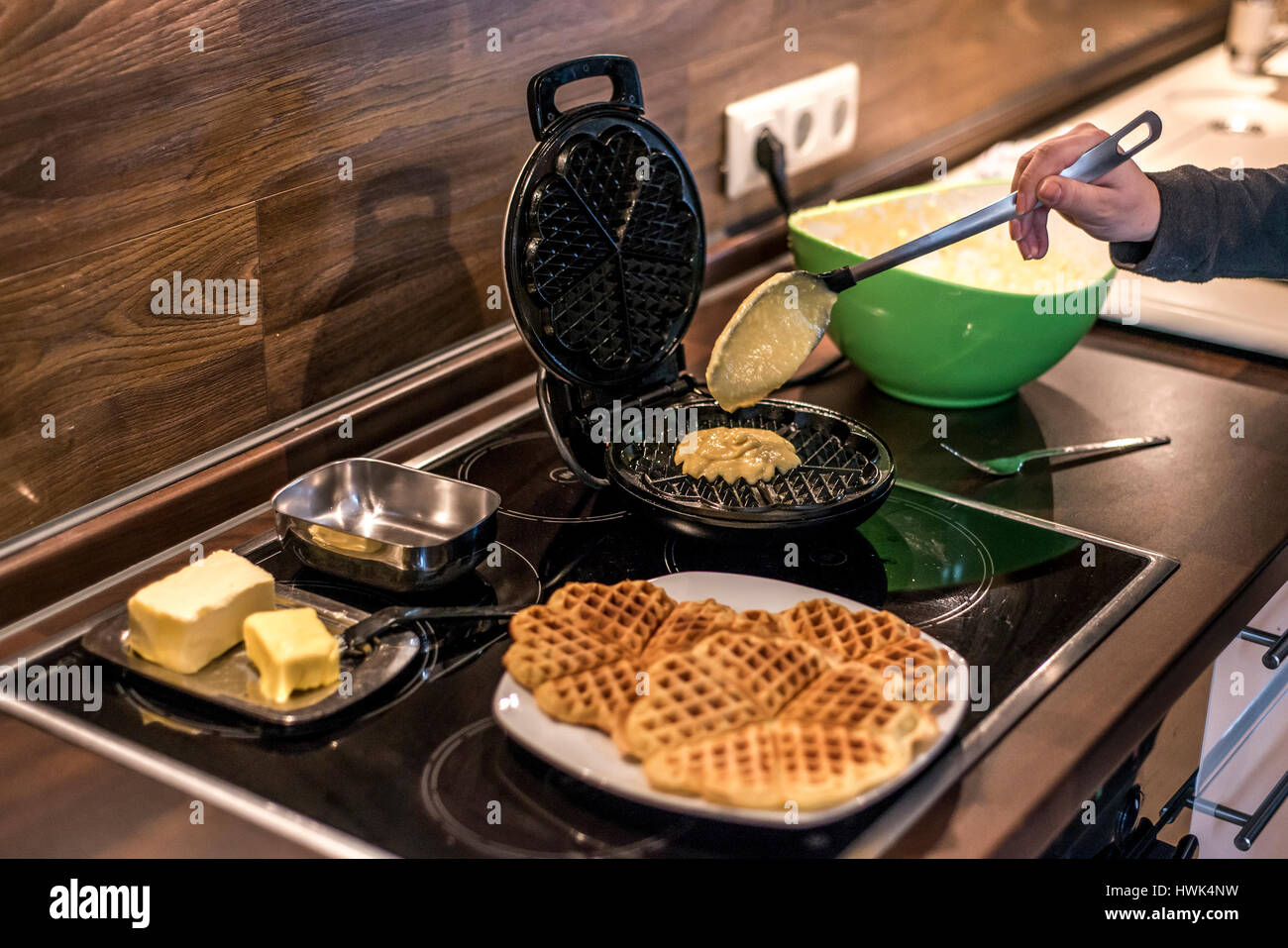 Hausgemachte Waffeln werden in einem Waffeleisen zubereitet. Stockfoto