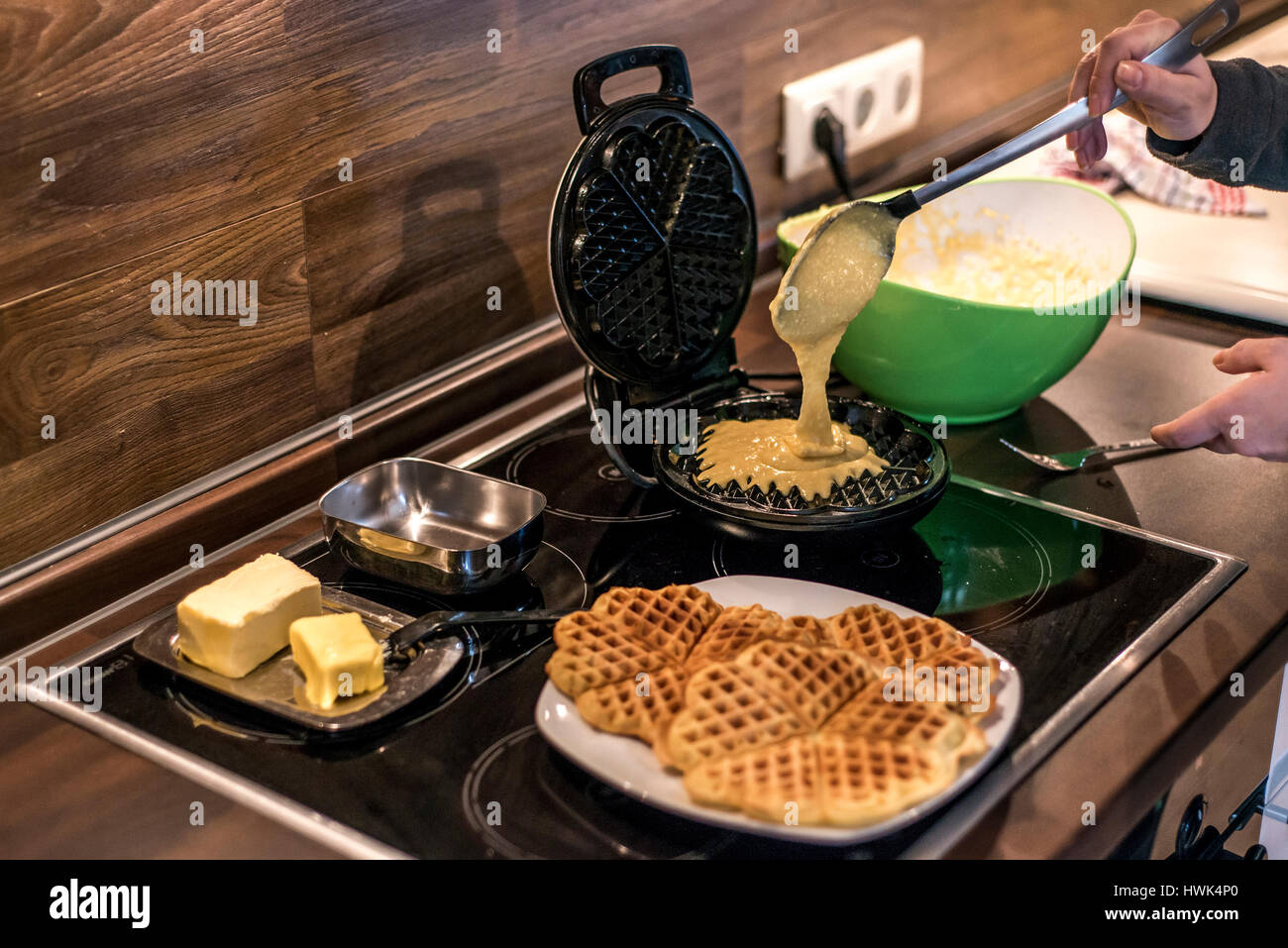 Hausgemachte Waffeln werden in einem Waffeleisen zubereitet. Stockfoto